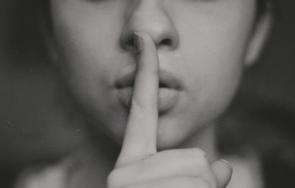 Girl with index finger at lips: "Shhh"